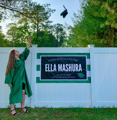 Custom Class of 2025 graduation banner outdoors in yard with graduate wearing her cap and gown and throwing her mortar board in the air