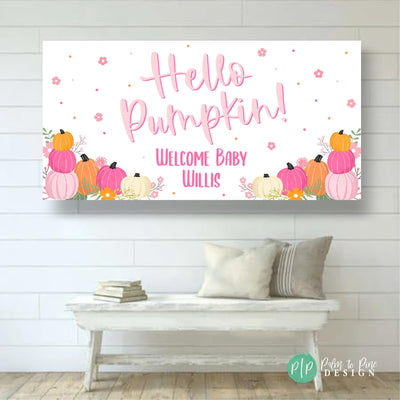 Pink and orange autumn-themed baby shower banner. The banner features the text &#39;Hello Pumpkin! Welcome Baby Willis.&#39;  Pumpkins in varying shades of pink, orange, and white are arranged along the bottom. Small pink flowers and gold dots are scattered across the white background.