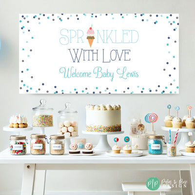 Sprinkled with Love Baby Shower Welcome Banner for boy baby shower featuring a  ice cream cone and a border of pastel blue sprinkles in front of a dessert table