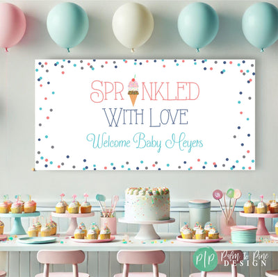 Sprinkled with Love’ baby shower banner displayed behind a dessert table filled with cupcakes, cookies, and sweet treats, creating a fun and festive backdrop