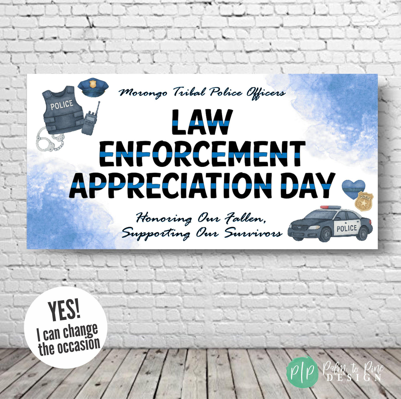 Law Enforcement Appreciation Day banner hung against a plain wall, featuring bold black and blue text with watercolor police gear and thin blue line elements, including a badge, patrol car, and heart