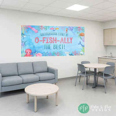 Underwater banner with sea creatures and the phrase ‘(school name) Elementary Staff is O-FISH-ALLY the Best!’ in bright, fun letters for under the sea themed teacher appreciation week celebration hung in staff room.