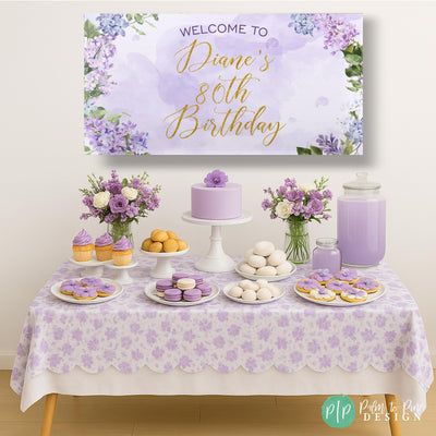 Purple floral birthday banner for women&#39;s birthday in front of lavender dessert table