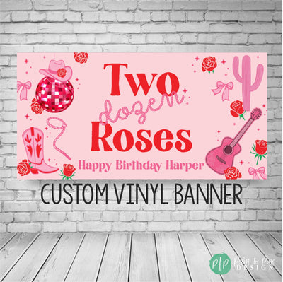Pink and red girls birthday banner with the wording Two Dozen Roses in a western cowgirl font and rope font for birthday party. Banner has a border of a disco ball, cowgirl hat and boot, cactus, acoustic guitar and roses sprinkled throughout