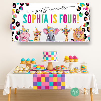 Neon rainbow leopard print birthday banner with safari animals in party hats, customized with child’s name and age, hanging above a dessert table at a jungle party.