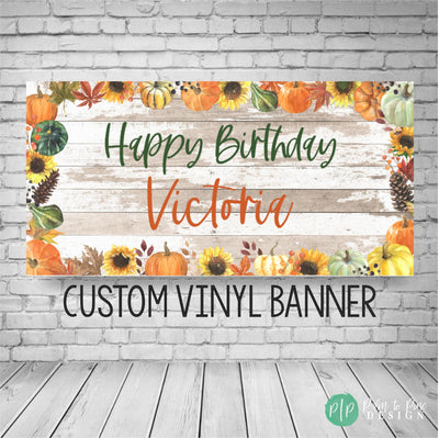 fall birthday banner with pumpkin, fall leaves and sunflower border and rustic wooden background. Happy Birthday and personalized name in modern, fun font