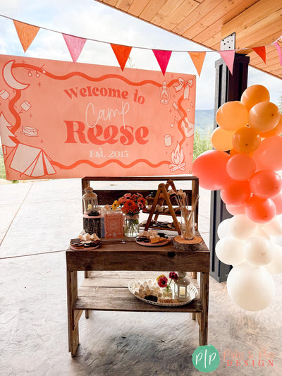 Glamping Birthday Party Welcome Banner, balloon garland, bunting flags and smores dessert table in pink, orange and coral warm color scheme