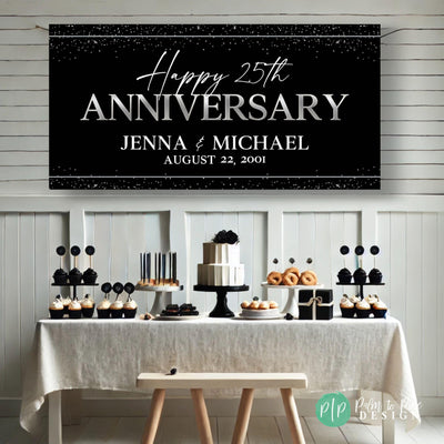 anniversary setup featuring custom vinyl banner behind a black and silver dessert table